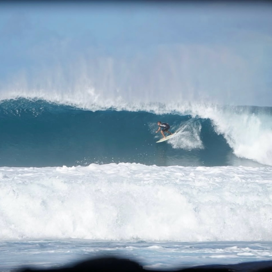 Line of surfers waiting beyond a breaking wave